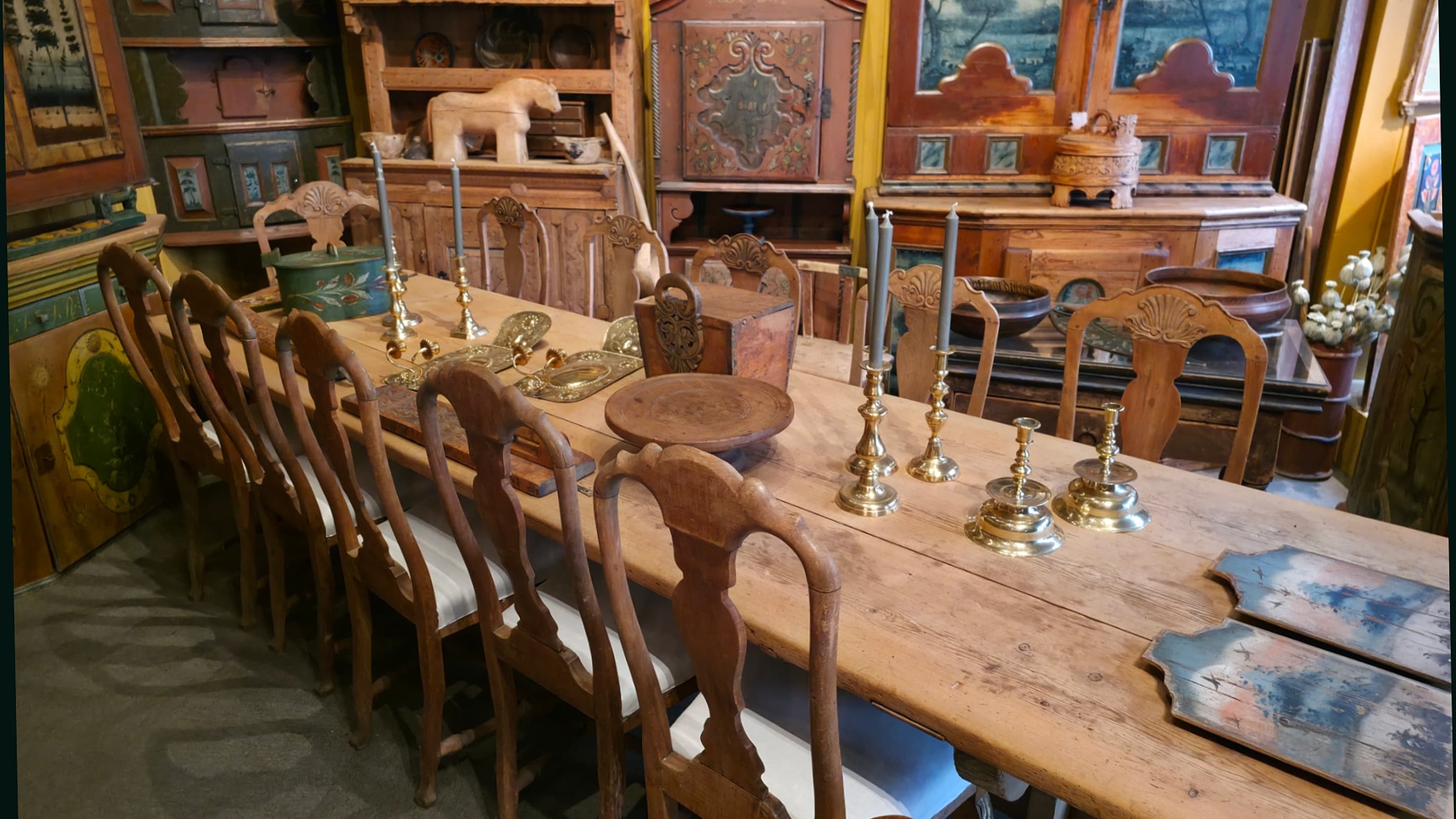 Langbord, stoler og rosemalte skap i butikken